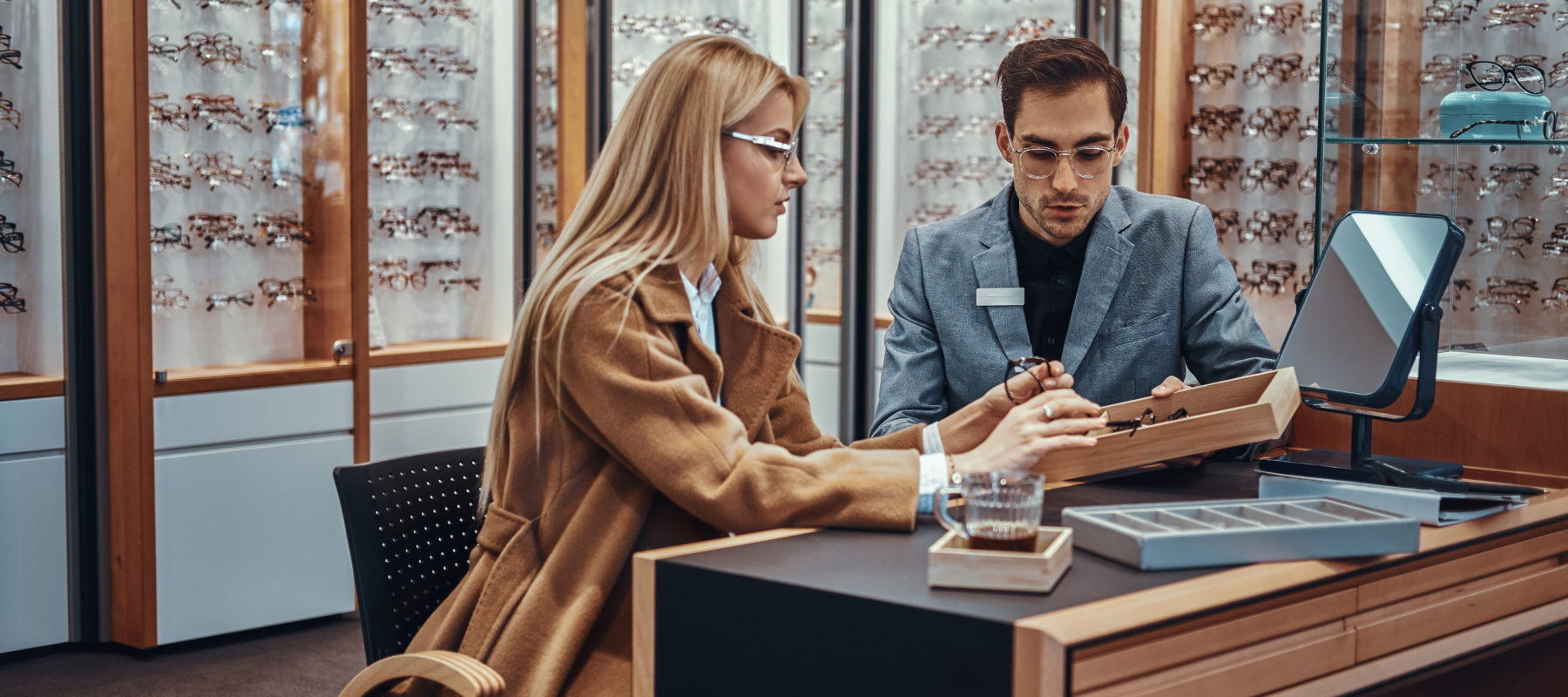 Optician helping patient choose glasses.