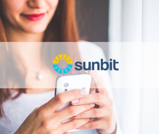 woman holding phone with Sunbit logo